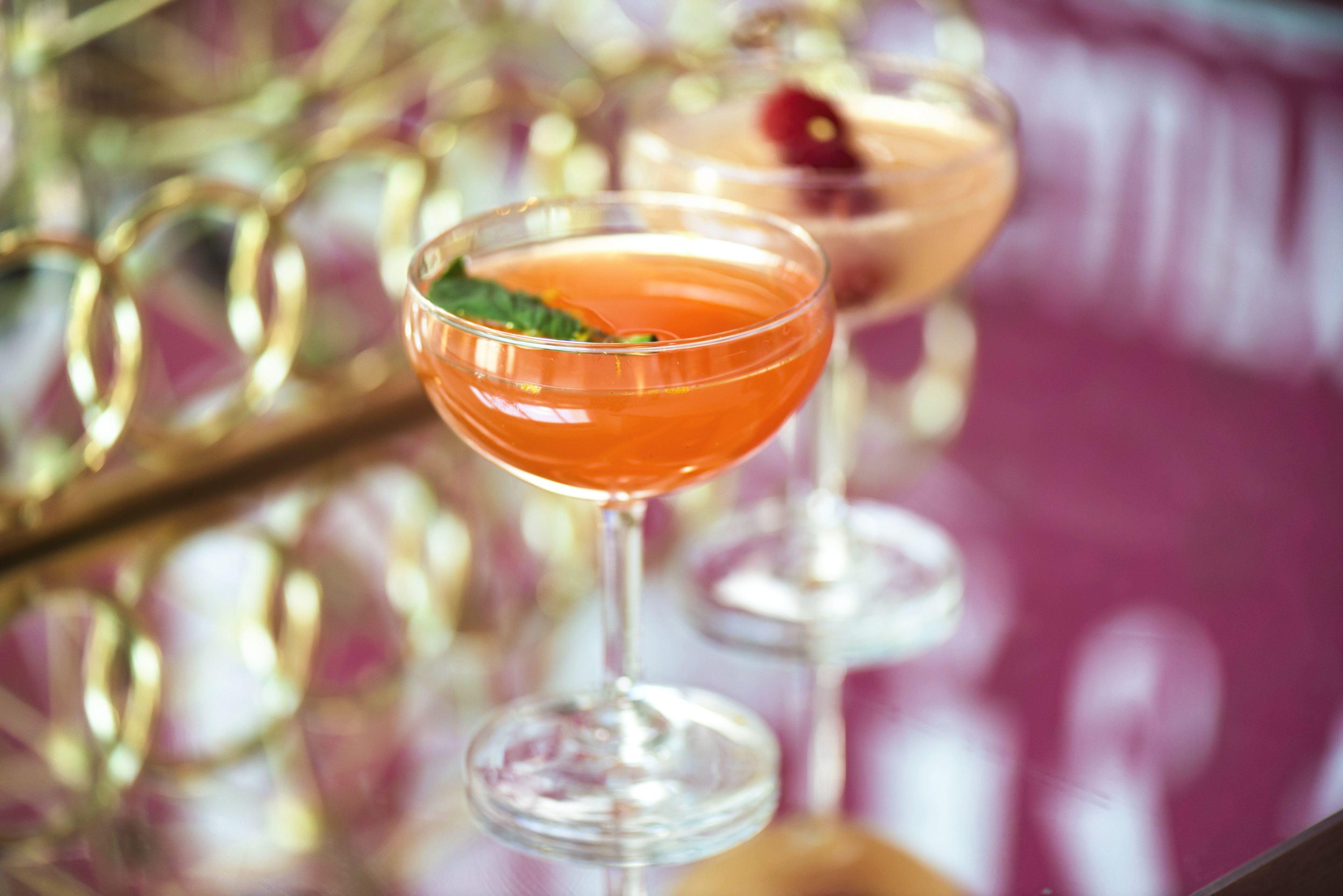 Orange and gold cocktails in coupe glasses