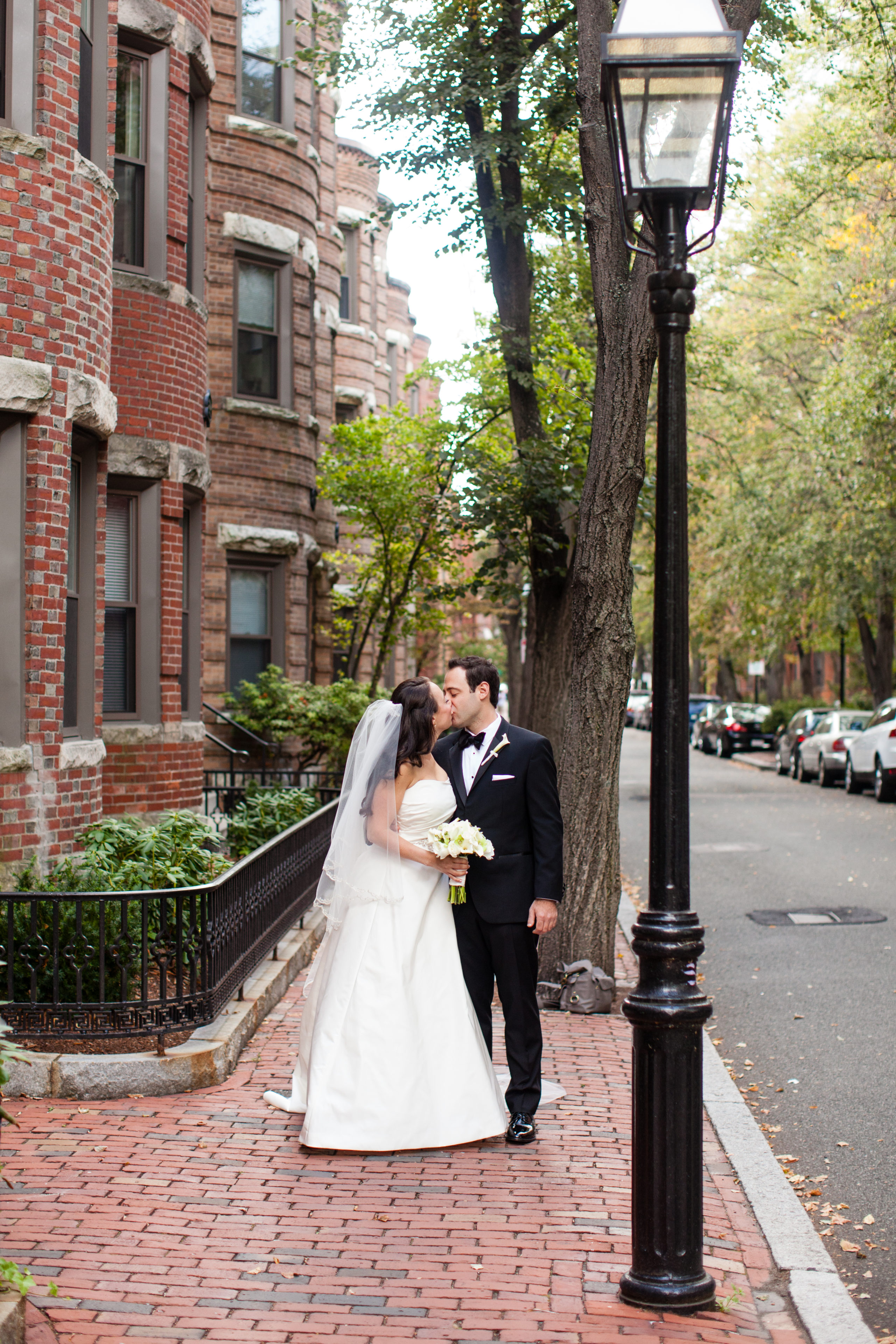 Just Married, this happy couple shares an intimate kiss on the sidewalk under a lamppost